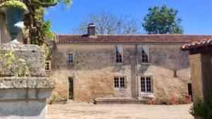 una vecchia casa in pietra con tetto rosso di Logis de La Touche a Saint-Hilaire-des-Loges