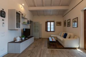 een woonkamer met een bank en een tv bij Vista Lago in Torre del Lago Puccini