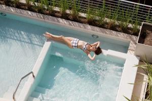 a woman is laying in a swimming pool at Palo Santo Hotel in Buenos Aires