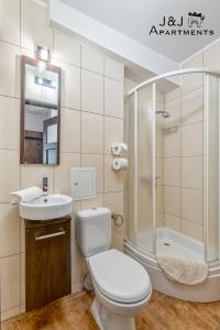 a bathroom with a toilet and a sink and a shower at J&J Apartments, Szczytna 1, Apartament 9 in Toruń +14 photos