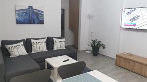 a living room with a couch and a tv at Sea Sound Apartment Mamaia Nord in Mamaia Sat/Năvodari