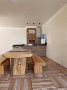 cocina con mesa de madera y banco en una habitación en Casa Raizes Salinópolis-PA en Salinópolis