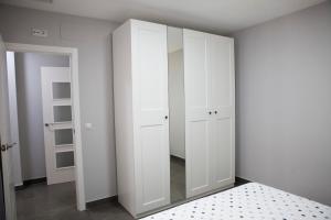 Miguel's House في بوزوبلانكو: غرفة نوم بها دواليب بيضاء ومرآة