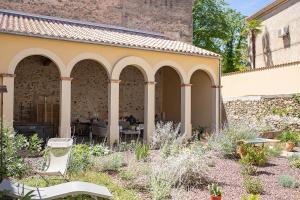 einen Garten mit einem Gebäude mit Bögen in der Unterkunft L'écrin de l'Orb in Cessenon