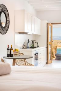 eine Küche mit weißen Schränken und einem Tisch mit Weinflaschen in der Unterkunft Lindian Ethos in Lindos
