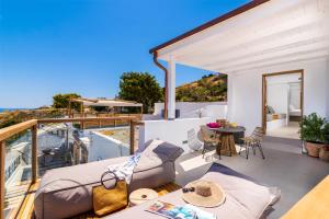 ein Balkon eines Hauses mit einem Tisch und Stühlen in der Unterkunft Lindian Ethos in Lindos