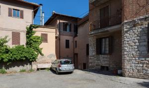 een auto geparkeerd op een parkeerplaats tussen twee gebouwen bij Il Profumo del Lauro in Perugia