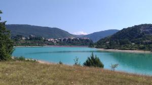 vistas a un lago con montañas en el fondo en Il Borgo 30 en Scapoli