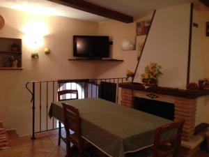 Il Borgo 30 في Scapoli: غرفة طعام مع طاولة ومدفأة وتلفزيون