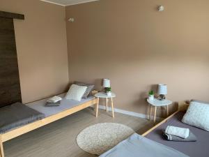 two beds in a room with two tables at Apartament Centrum in Świdnica