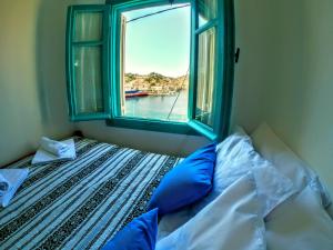 Bett mit einem Fenster mit Blick auf das Wasser in der Unterkunft Villa Pitini in Symi