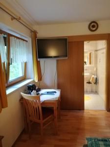 a room with a table and a television on the wall at Haus Georg in Innsbruck