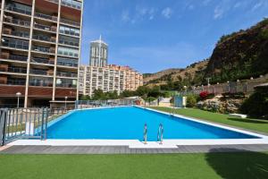 a large blue swimming pool in front of a building at Mirador del Mediterraneo in Benidorm