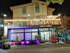 Hotel Ristorante La Casareccia في فيوجي: مبنى عليه شرفة في الليل +15 صورة
