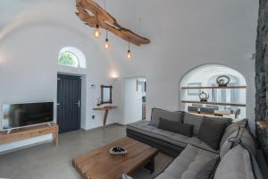 a living room with a couch and a table at Secret Spot Luxury Villa in Fira