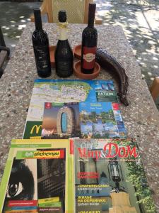 a table with two bottles of wine and a magazine at Hotel Liza in Batumi