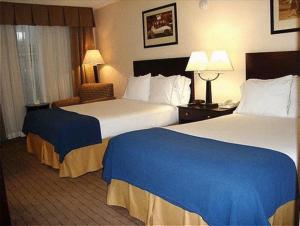 a hotel room with two beds and a chair at Holiday Inn Express Little Rock-Airport, an IHG Hotel in Little Rock
