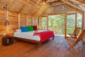 a bedroom with a bed in a wooden cabin at Canto del Agua Ecolodge in Comitán