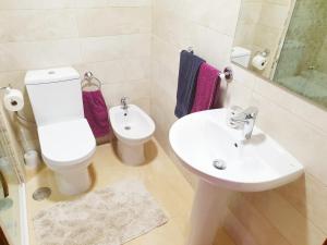 a white bathroom with a toilet and a sink at Carmen Apartments in Benidorm +19 photos