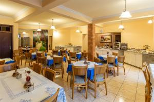 a restaurant with tables and chairs and a kitchen at Boroni Palace Hotel in Ouro Preto