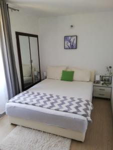 a bedroom with a large white bed and a mirror at Apartment Vista Viganj in Viganj