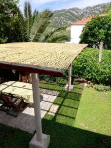 un techo de paja sobre una mesa en un patio en Apartment Vista Viganj, en Viganj