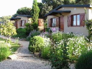 Casas de Belvis的住宿－La Cerca Del Alcornoque，鲜花屋前的花园