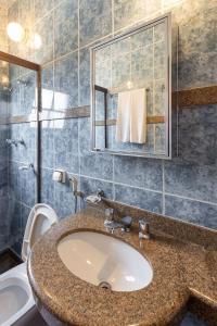 een badkamer met een wastafel, een toilet en een spiegel bij Boroni Palace Hotel in Ouro Preto