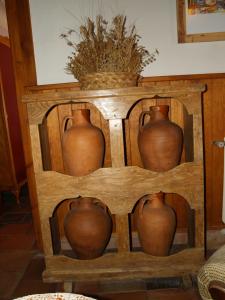 un grupo de jarrones sentados en un estante en Casa rural Callejón del Palacio, en Muñoveros