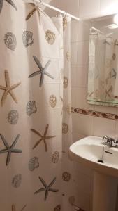 baño con lavabo y cortina de ducha con estrella de mar en Apartamento turístico Dayma 2 en Jarandilla de la Vera