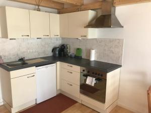 a kitchen with white cabinets and a stove top oven at Knusperhaus mit Garten in Salzburg