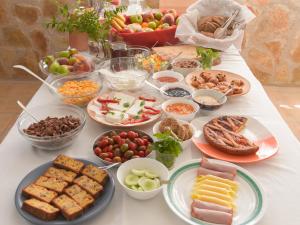 a table topped with lots of different types of food at Londos Hotel in Piso Livadi