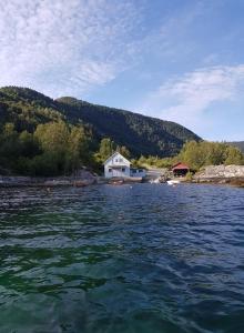 una casa en medio de un cuerpo de agua en Waerholmen, en Lavik