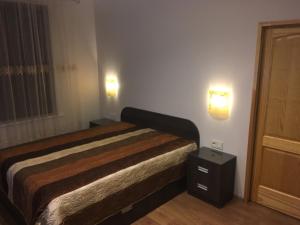 Un dormitorio con una cama y dos luces en la pared. en Gaisma, en Ventspils