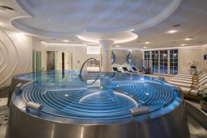 a large pool with blue water in a room at Palace Art Hotel Pezinok in Pezinok