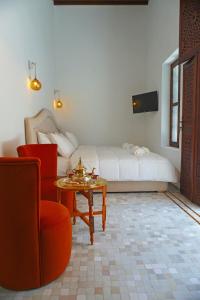 - un salon avec un lit, une table et une chaise dans l'établissement Dar Fama, à Tetouan