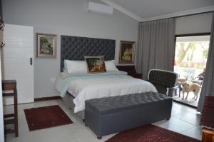 a bedroom with a bed with a bench and a dog at 64 on Malabor in Pretoria