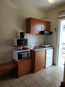 a kitchen with brown cabinets and a microwave and a stove at Amalia in Paleo Tsifliki