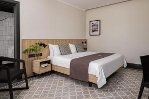 a bedroom with a large bed and a chair at La Falconeria Hotel in Valletta