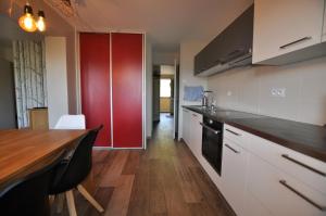 eine Küche mit einem Holztisch und einem roten Schrank in der Unterkunft La Montagne in Les Coches