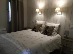 ein Schlafzimmer mit einem weißen Bett mit zwei Kissen in der Unterkunft La Montagne in Les Coches