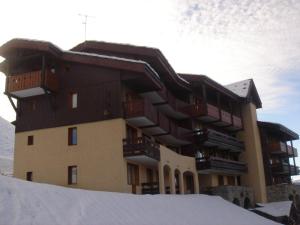 ein großes Gebäude mit Schnee davor in der Unterkunft La Montagne in Les Coches