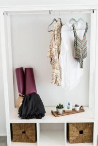 a white shelf with clothes and baskets on it at SECRET HILL in Athani