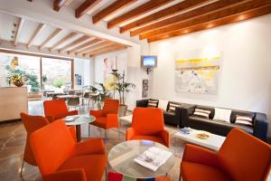 sala de estar con sillas de color naranja y sofá en L'Host Boutique Rooms en Pollença