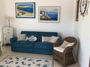 a living room with a blue couch and a chair at Nel Blu Dipinto Di Blu in Polignano a Mare