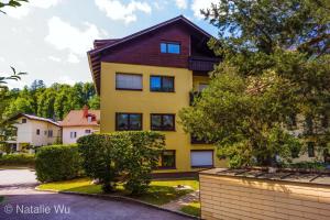 una casa amarilla con techo marrón en Apartment Ischl Home, en Bad Ischl