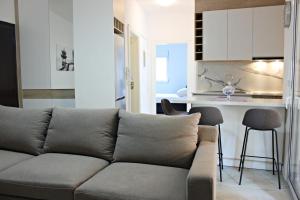 a living room with a couch and a kitchen at Erin Luxury Home in Sarandë