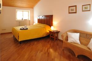 1 dormitorio con cama amarilla y sofá en Bed & Breakfast Pegaso, en Valeggio sul Mincio