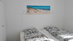 a room with two beds and a picture on the wall at Ferienwohnungen und Haushälfte Friesland in Midlum