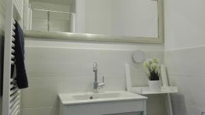 a white bathroom with a sink and a mirror at Ferienwohnungen und Haushälfte Friesland in Midlum +21 photos
